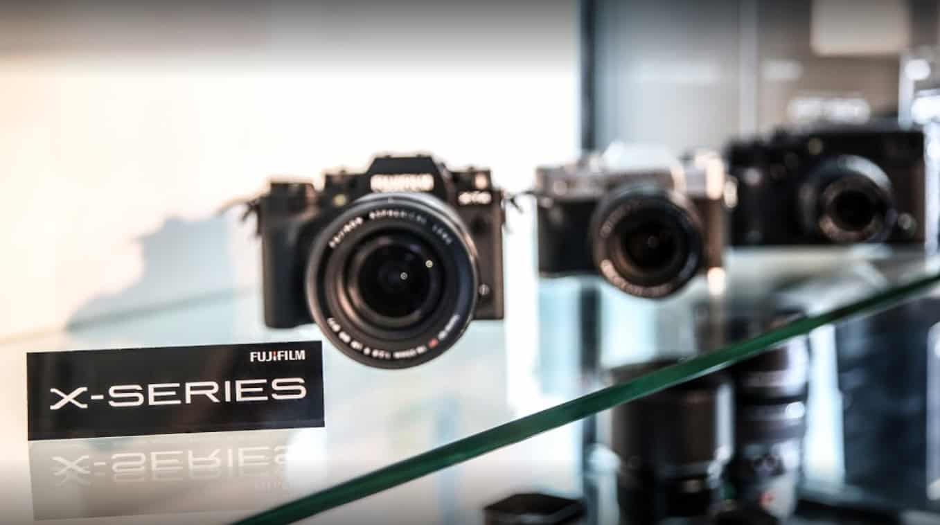 Verschiedene Fujifilm X-Serie Kameras auf einem Glasregal ausgestellt.